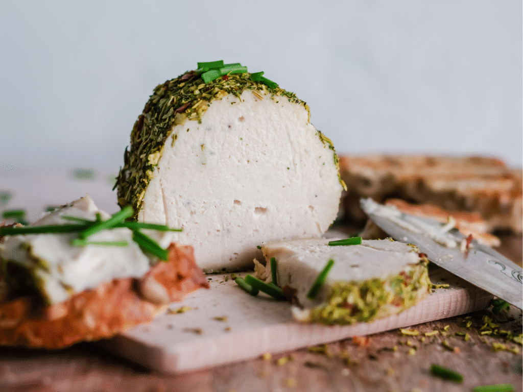 Delicious soft white vegan cheese with a herb crust and chewy sourdough bread