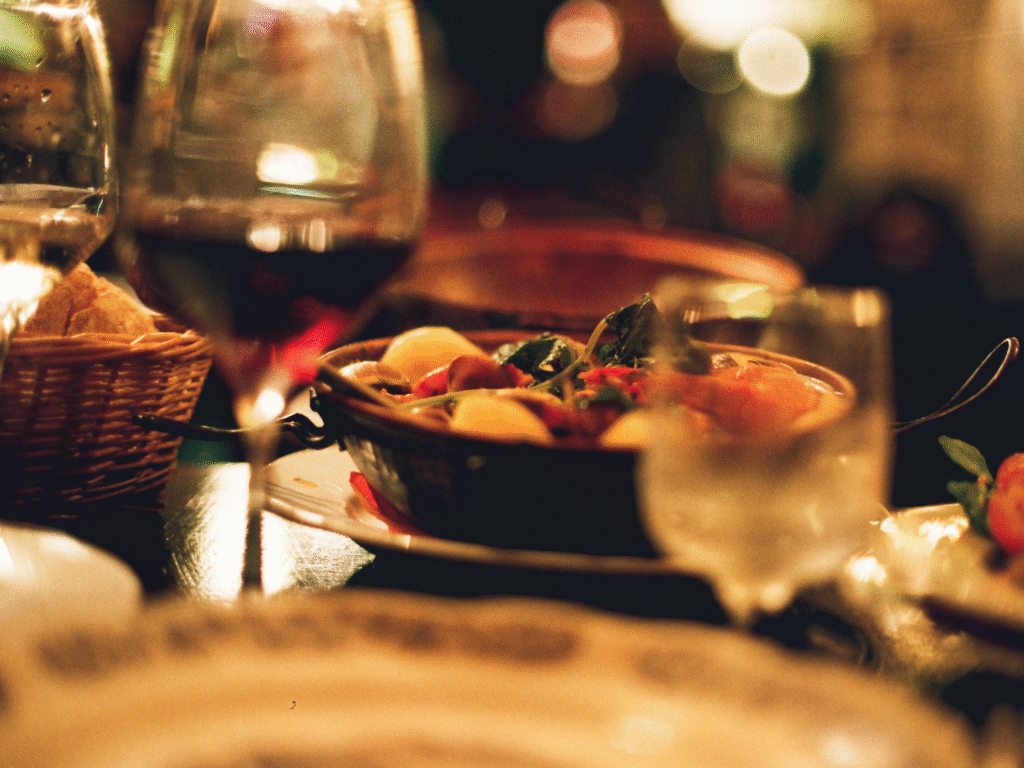 A cozy table spread with a glass of red wine